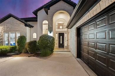 Exterior entry at dusk with stone siding, a garag