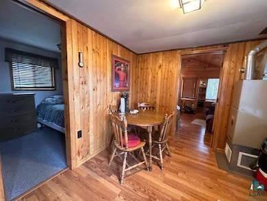 Dining space featuring wooden walls and wood finished floors