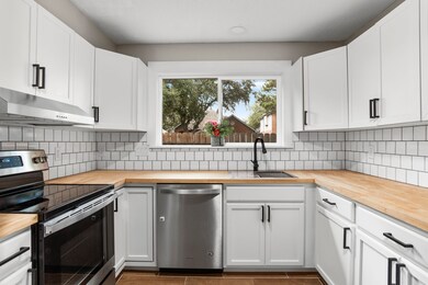 This beautiful kitchen boasts white cabinets, blac