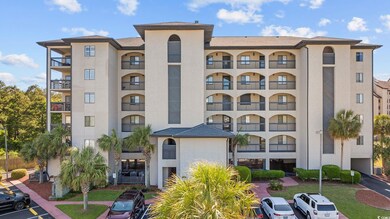 View of apartment building / complex featuring uncovered parking