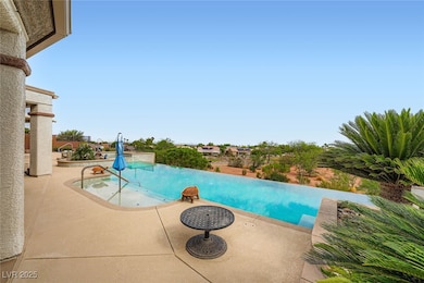 View of pool with a patio and an infinity pool and