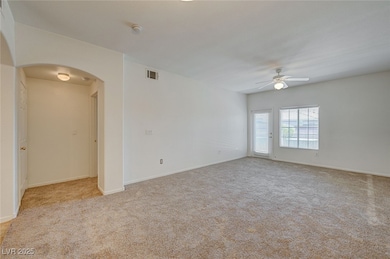Empty room with light carpet and arched walkways