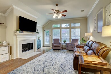 The den has a fireplace and floor to ceiling windows overlooking the beautiful pool.