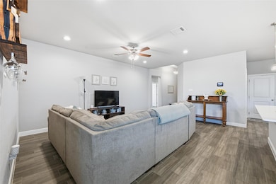 Living room featuring ceiling fan, dark wood-type flooring, and recessed lighting