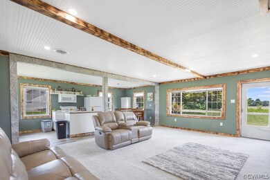 Carpeted living room featuring beam ceiling