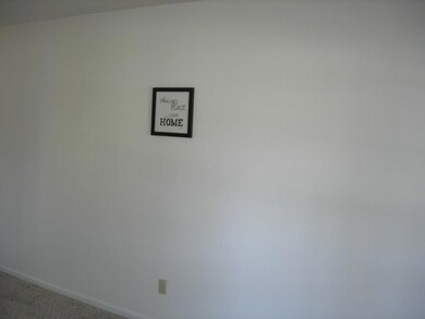 Den/Family room with carpet and bay windows.