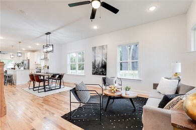 Living room with ceiling fan with notable chandeli