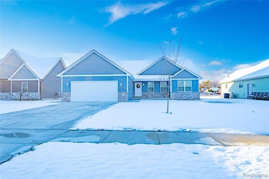 Craftsman-style home with stone siding, driveway, and a garage
