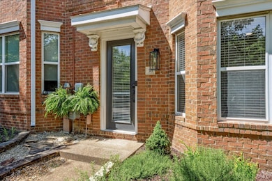 Entrance to property featuring brick siding