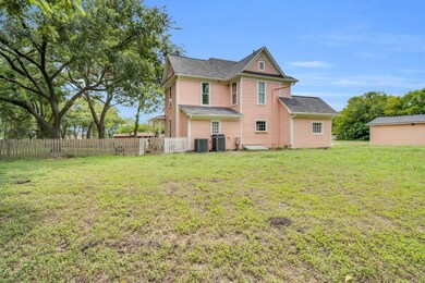 Rear view of house with cooling unit and a lawn