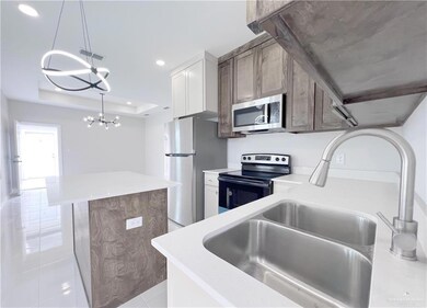 Kitchen with a kitchen island, visible vents, a sink, a notable chandelier, and stainless steel appliances