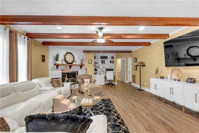 Living room featuring baseboards, light wood finis
