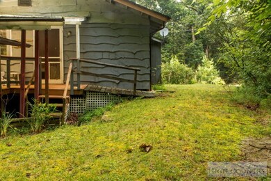 Back of the Home: The cabin includes a wrap around deck that extends to the back of the home and is covered. The steps lead down to a storage shed and the garage.