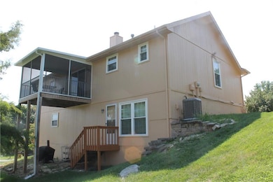 Rear view of house featuring a yard and a chimney