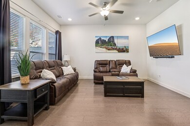 Living area featuring light wood-style flooring, a ceiling fan, and recessed lighting