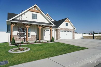 Modern farmhouse with board and batten siding, brick siding, concrete driveway, and covered porch