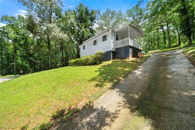 View of property exterior featuring asphalt driveway and a yard