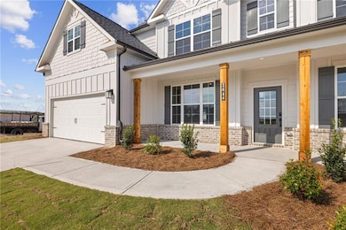 View of front of property featuring board and batten siding, a porch, driveway, and an attached garage