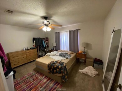 Carpeted bedroom with a textured ceiling and ceili