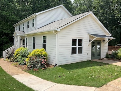 View of front of home featuring french doors, a front yard, and a shingled roof