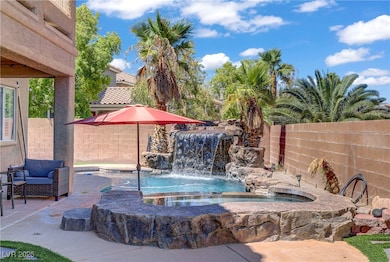 View of pool with an in-ground hot tub and a fenced backyard
