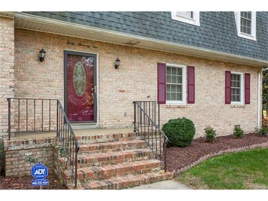 BRICK FRONT PORCH WITH IRON RAILING AND LANDSCAPED