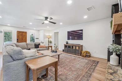Living room with recessed lighting, light wood finished floors, and a ceiling fan