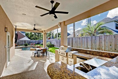 Kitchen includes granite counters with gas grill, side burner, refrigerator, ice chest, and sink, and guest bar.