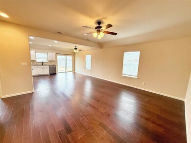 Kitchen featuring decorative backsplash, white cabinets, stainless steel appliances, and ceiling fan