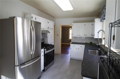 Kitchen featuring under cabinet range hood, a sink