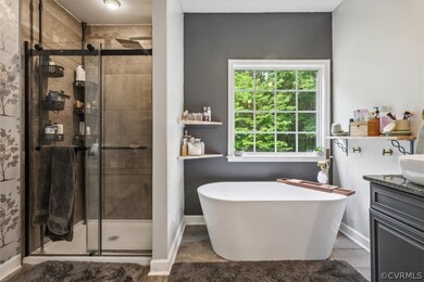Bathroom with walk in shower, vanity, and tile flo