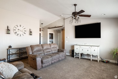 Carpeted living area with lofted ceiling and a ceiling fan