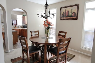 Dining area featuring arched walkways, light carpe