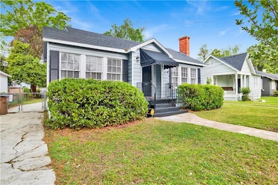 Bungalow with roof with shingles, fence, a front y
