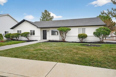 Single story home with a front yard, stucco siding, and a shingled roof