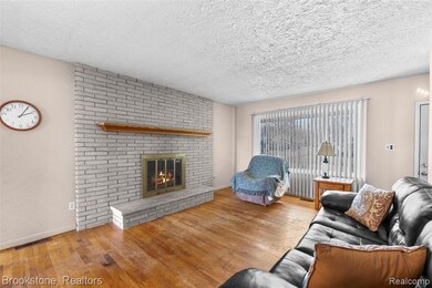 Living room with a brick fireplace, and wood finished floors