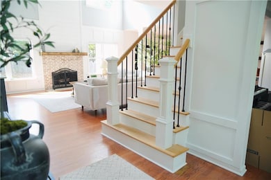 Stairway featuring a brick fireplace and wood fini