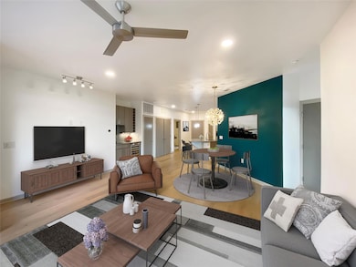Living area with ceiling fan, light wood-style fl