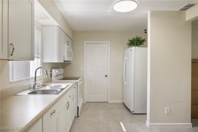 Kitchen with visible vents, white appliances, ligh