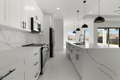 Kitchen with pendant lighting, sink, white cabinet