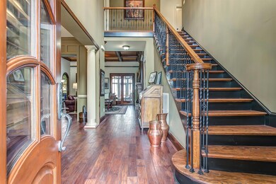 A dramatic staircase with hardwood stair treads and wrought iron spindles provides an impressive first impression as you begin to  take in this remarkable home’s open floor plan.