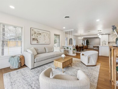 Living area featuring wood finished floors, recessed lighting, and a chandelier