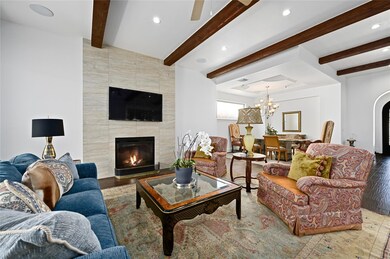 Living area featuring a tile fireplace, beam ceil