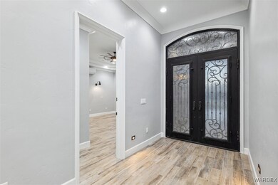 Entryway featuring crown molding, ceiling fan, fre