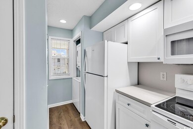 Kitchen with white appliances, stacked washer and 