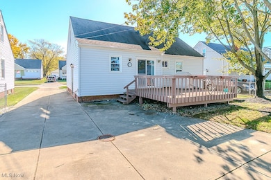 Back of property featuring a deck and roof with shingles