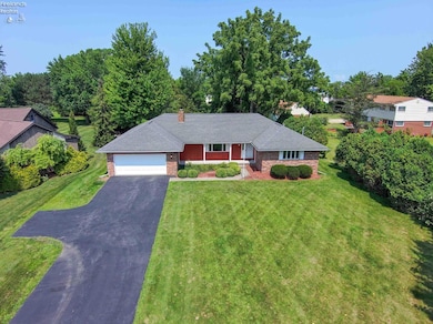 Drone view of the property, driveway has an extra parking pad.