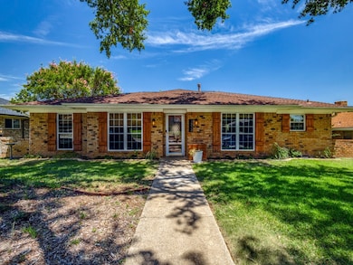 Ranch-style house with a front lawn and brick siding
