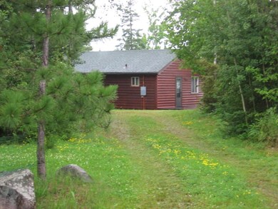 View of side of home with faux log siding, roof with shingles, and a yard