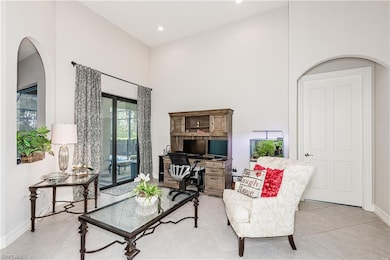 Living area with a towering ceiling, baseboards, light tile patterned floors, and recessed lighting